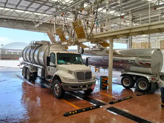 Tortón TRESAL en operación de lavado interior en el centro de lavado de autotanques de San Luis Potosí, con pasarela superior y semirremolque de acero inoxidable al lado